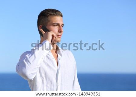 Attractive man talking on the phone with the sea in the background