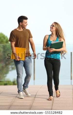Teenager students boy and girl walking towards camera and smiling
