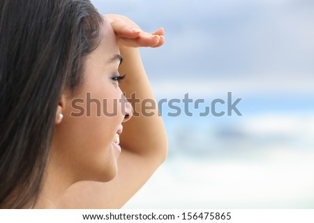 Close Up Of A Beautiful Woman Looking At The Horizon With A Hand In Forehead With The Sky In The Background