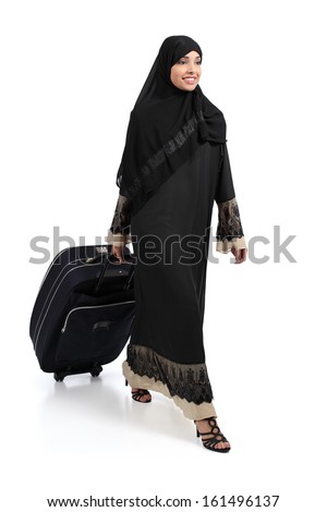 Arab woman walking carrying a suitcase isolated on a white background Arab woman walking carrying a suitcase isolated on a white background