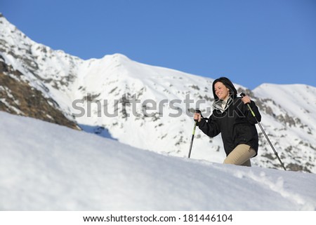 Hiker happy woman trekking on the snow in a snowy mountain in winter