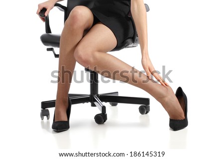Business woman touching feet with her hand isolated on a white background Business woman touching feet with her hand isolated on a white background