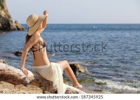Beauty woman on the beach looking at horizon on vacations with the horizon in the background