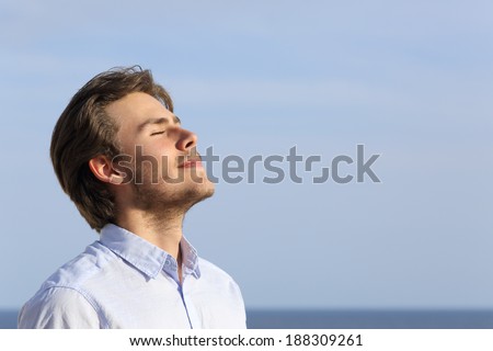 Happy young man breathing deep with the horizon in the background