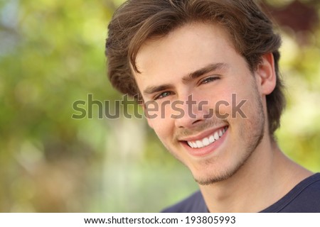 Handsome man face with a white perfect smile with a green background