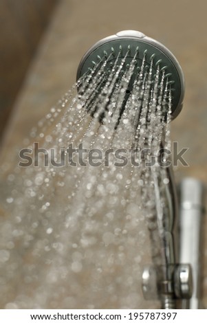 Close up of a shower head flowing water in a bathroom cabin
