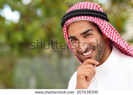 Portrait of a handsome arab saudi emirates man with a white smile and a green background