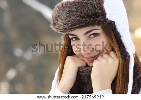 Beauty woman face portrait warmly clothed in winter holding a scarf outdoors