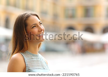 Portrait of a cheerful tourist woman looking at side in a touristic place in vacations