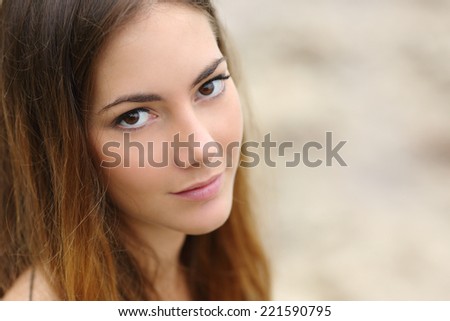 Portrait of a beautiful woman with big eyes and smooth skin looking at camera