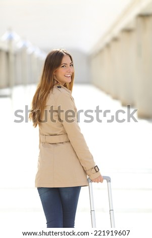 Traveler tourist woman walking and looking at camera through a corridor of an airport
