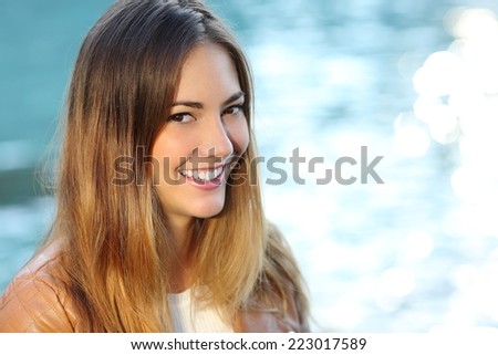 Happy girl with perfect smile and white tooth on the beach isolated in white on the right side