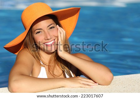 Girl on holidays with a perfect white smile bathing in a pool on vacations Girl on holidays with a perfect white smile bathing in a pool on vacations