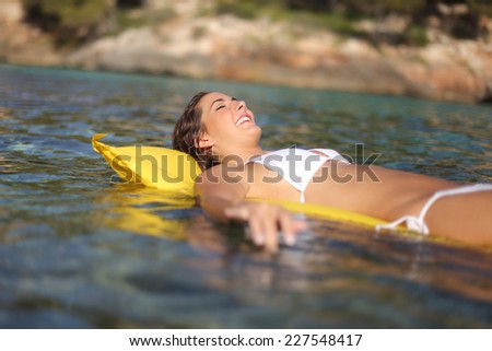Woman bathing on an inflatable bed on the beach on summer vacations