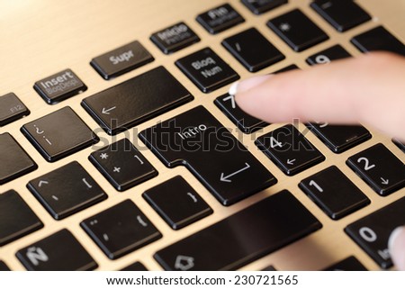 Close up of a finger pushing enter key in a laptop computer keyboard