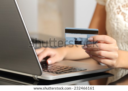 Close up of a woman hands buying online with a credit card and a laptop. Ecommerce concept