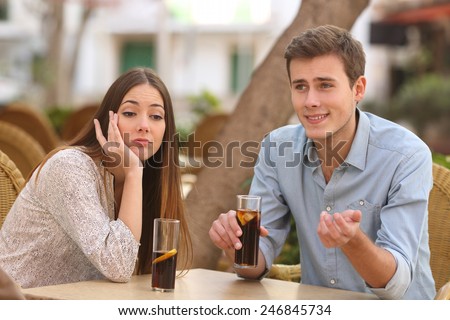 Man and woman dating in a restaurant terrace but she is boring while he telling lies