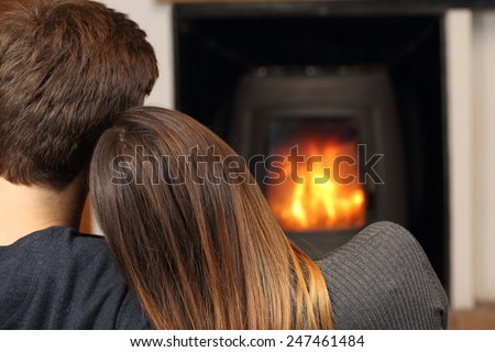 Comfortable couple hugging at home resting near fire place