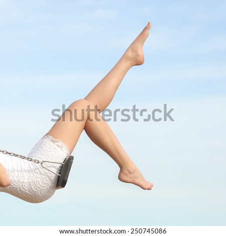 Perfect woman waxing hair removal legs swinging with the blue sky in the background