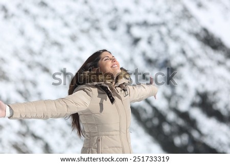 Fashion woman breathing fresh air in a snowy mountain in winter holidays