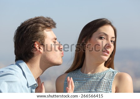 Friend zone concept with a man trying to kiss a woman and she rejecting him