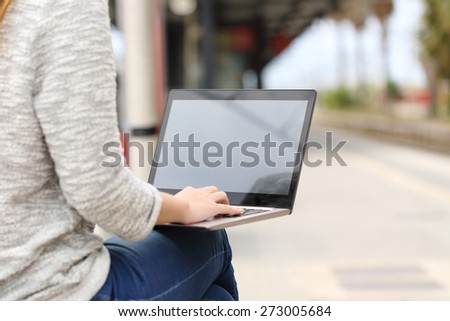 Entrepreneur working with a laptop in a train station and showing a blank screen
