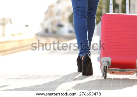 Traveler woman legs walking with luggage in a train station while she is waiting