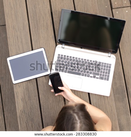 Girl lying in a park searching job in multiple devices showing a blank screens
