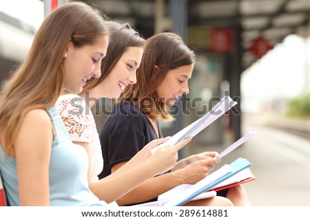 Profile of three students studying and learning reading notes in a train station