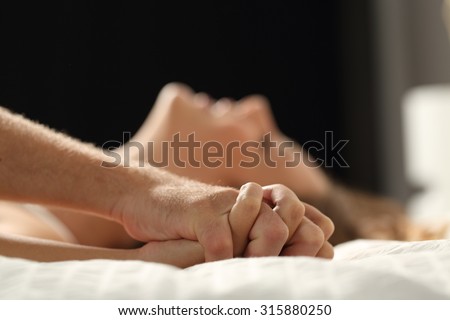 Close up profile of a couple having sex on a bed at home in the night