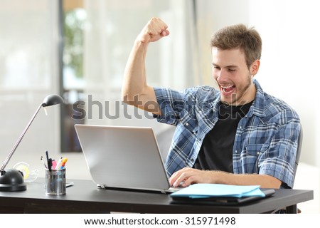 Euphoric winner happy man using a laptop in a desk at home