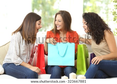 Happy shoppers with shopping bags talking sitting on a couch at home