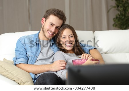 http://image.shutterstock.com/display_pic_with_logo/1020994/334277438/stock-photo-happy-couple-watching-a-movie-on-tv-sitting-on-a-couch-at-home-334277438.jpg