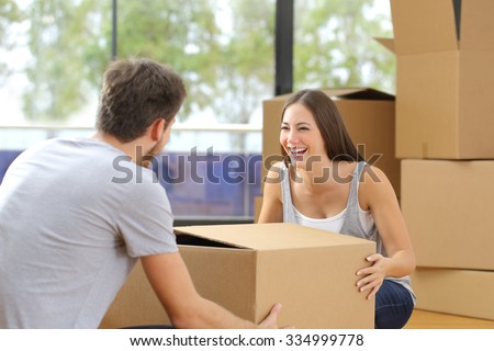 Happy couple or marriage lifting box moving home