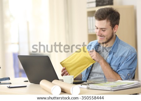Entrepreneur opening a padded envelope in a little office or home