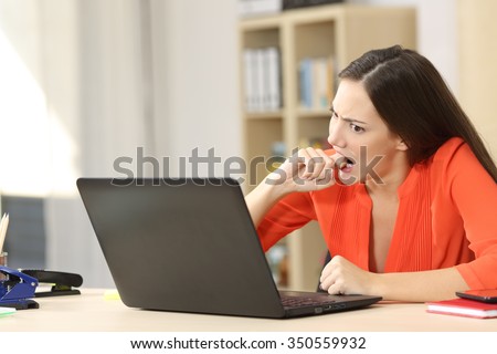 Angry entrepreneur furious with a laptop working in an office or home
