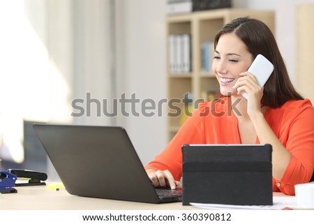 Entrepreneur working on line with multiple devices in a desk in a little office or home