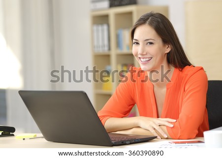 Happy entrepreneur or freelancer looking at camera sitting in an office or home