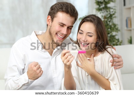 Happy excited couple making positive pregnancy test and celebrating