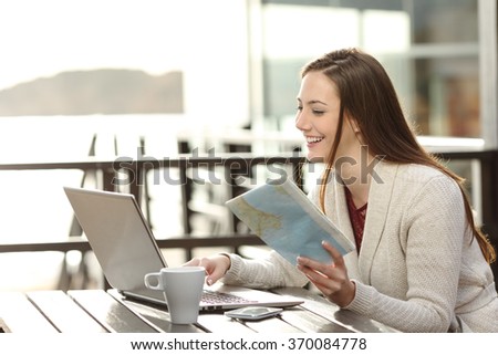 Happy woman planning vacations on line searching information in a laptop in a resort or hotel in the beach