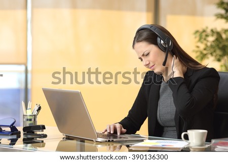 Stressed businesswoman suffering neck ache while is working on line sitting in a desktop at office