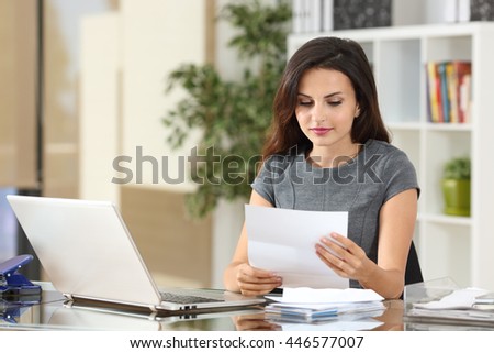 Portrait of a businesswoman working at office reading a letter in a desktop