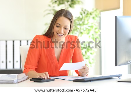 Businesswoman wearing orange blouse doing accounting and calculating with a calculator in a desktop at office