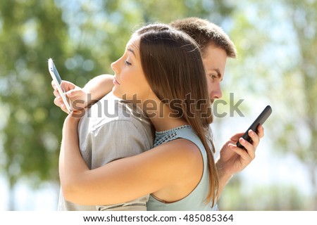 Couple of cheaters hugging and texting everyone on their smart phones