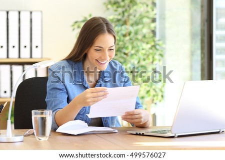 Happy entrepreneur woman reading good news in a letter in a desk at office