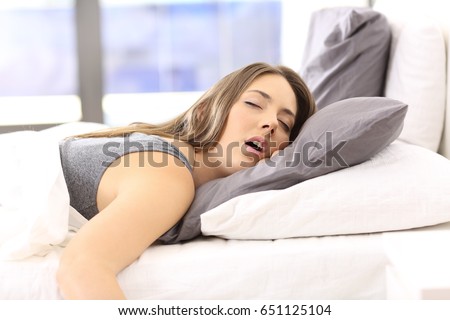 Tired single woman resting on the bed of an hotel room or home