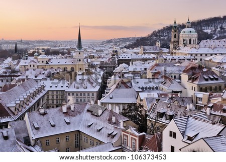 City roofs covered with snow below a pink sky, Prague, Czech Republic