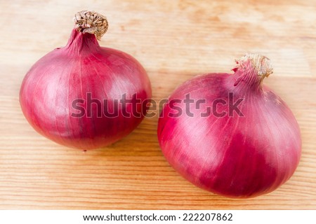 Red onion bulb on wood cut board, Close-up of fresh red onions on a wooden background,