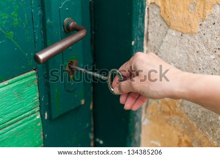 Hand open old door with old key