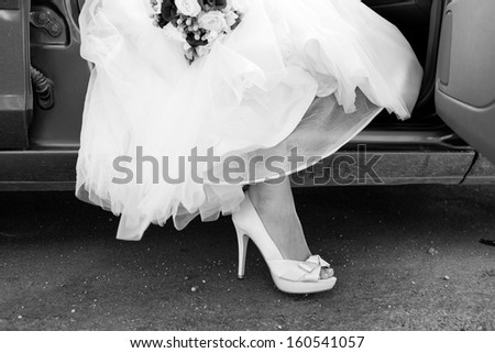 Shoe of the bride, bride with leg outside of car, black and white